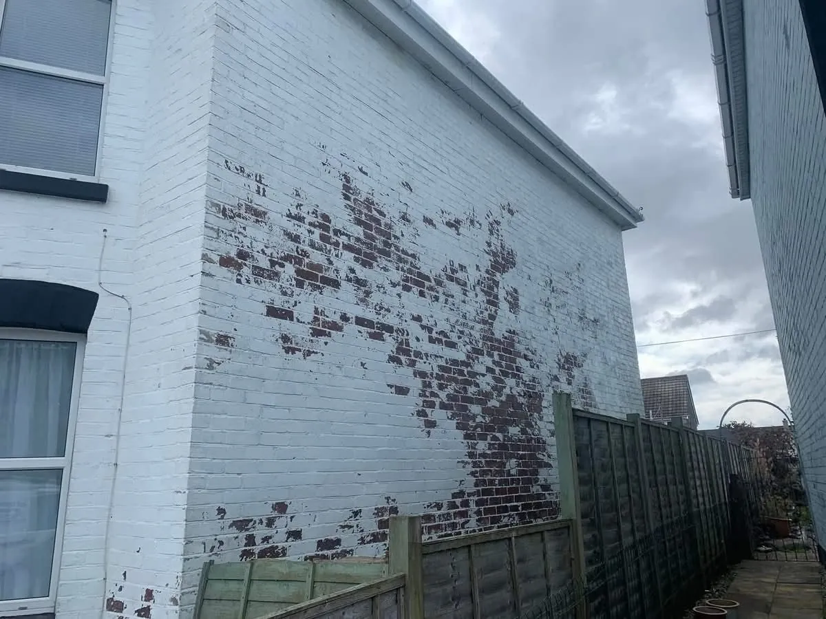 Peeling paint on a brick wall before redecoration in Fowey