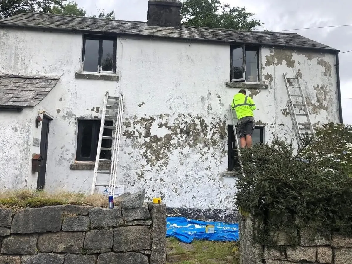 Cottage with blown, flaking render before repair in Fowey